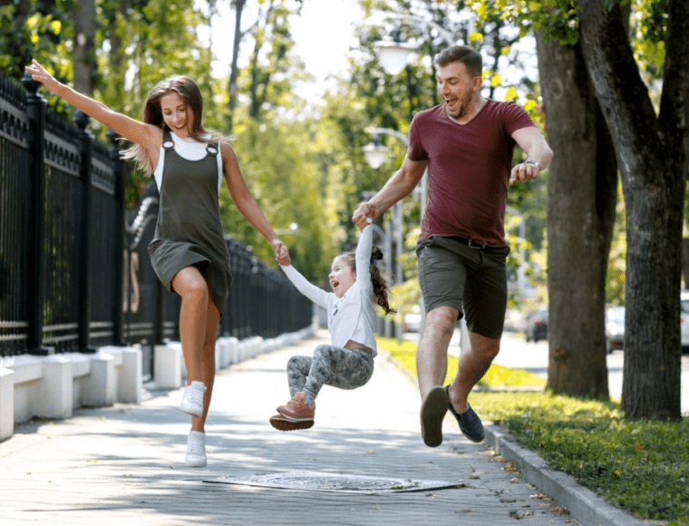 A happy family jumping in the air with their child.