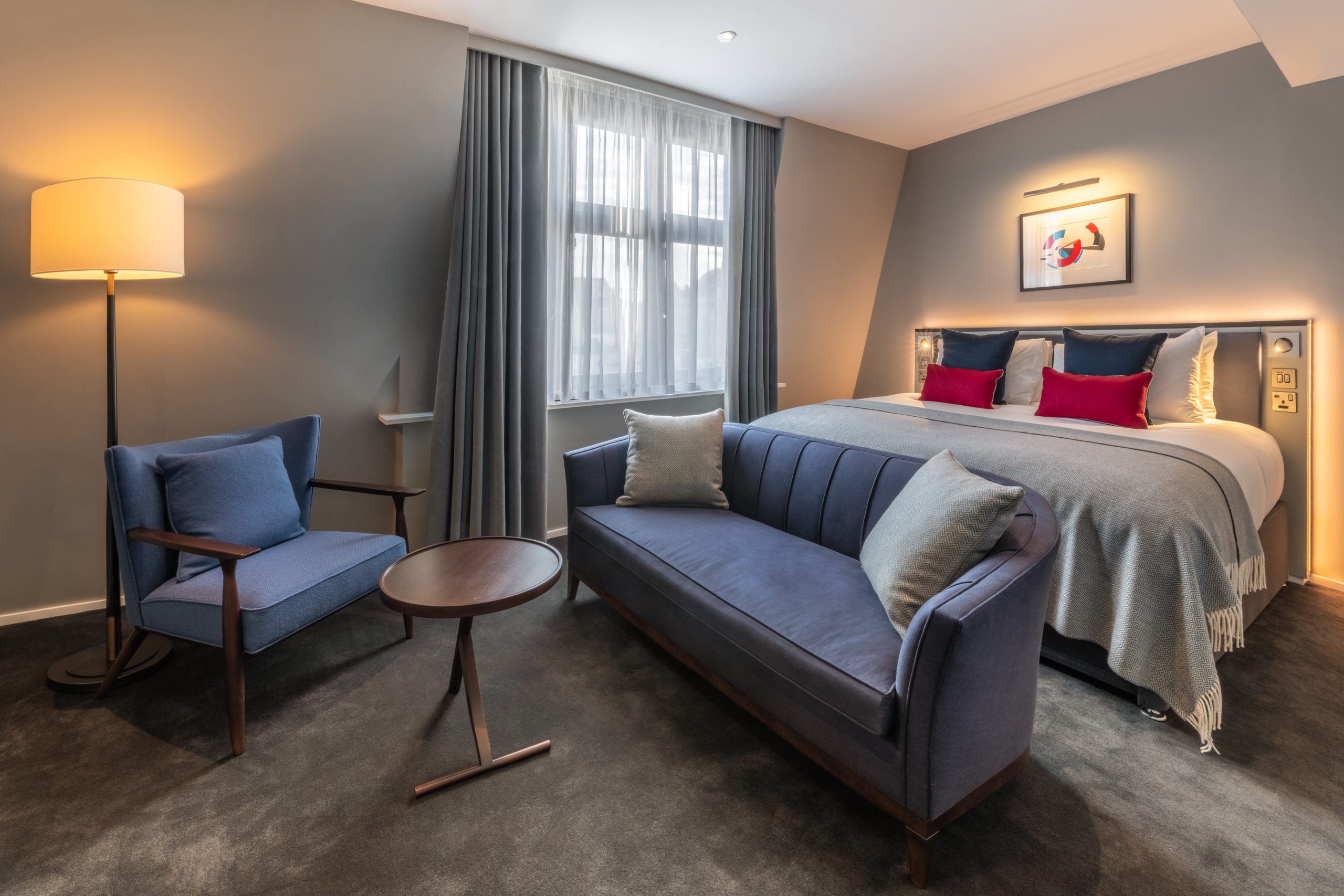 A junior suite with a double bed, a small dining area and a sofa, located in Covent Garden.