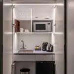 A miniature kitchen, with a built in fridge and microwave.