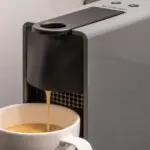 A coffee machine, pouring coffee into a mug.