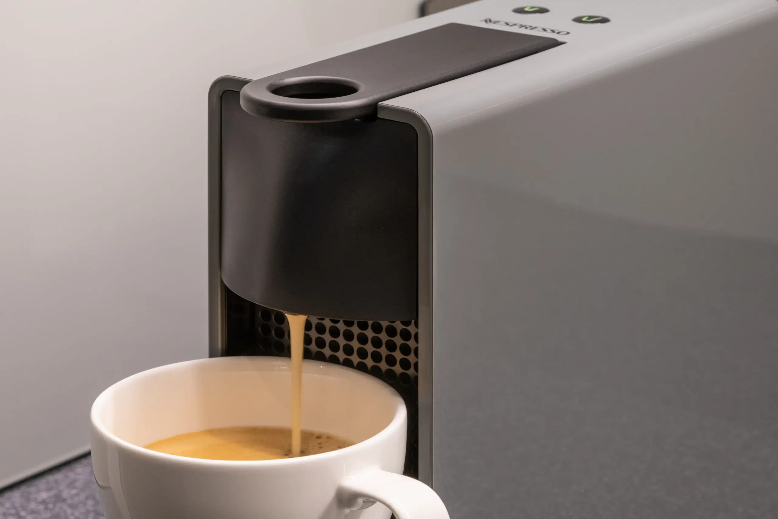 A coffee machine, pouring coffee into a mug.