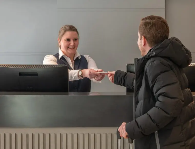 A customer receiving a key card at The Resident reception.