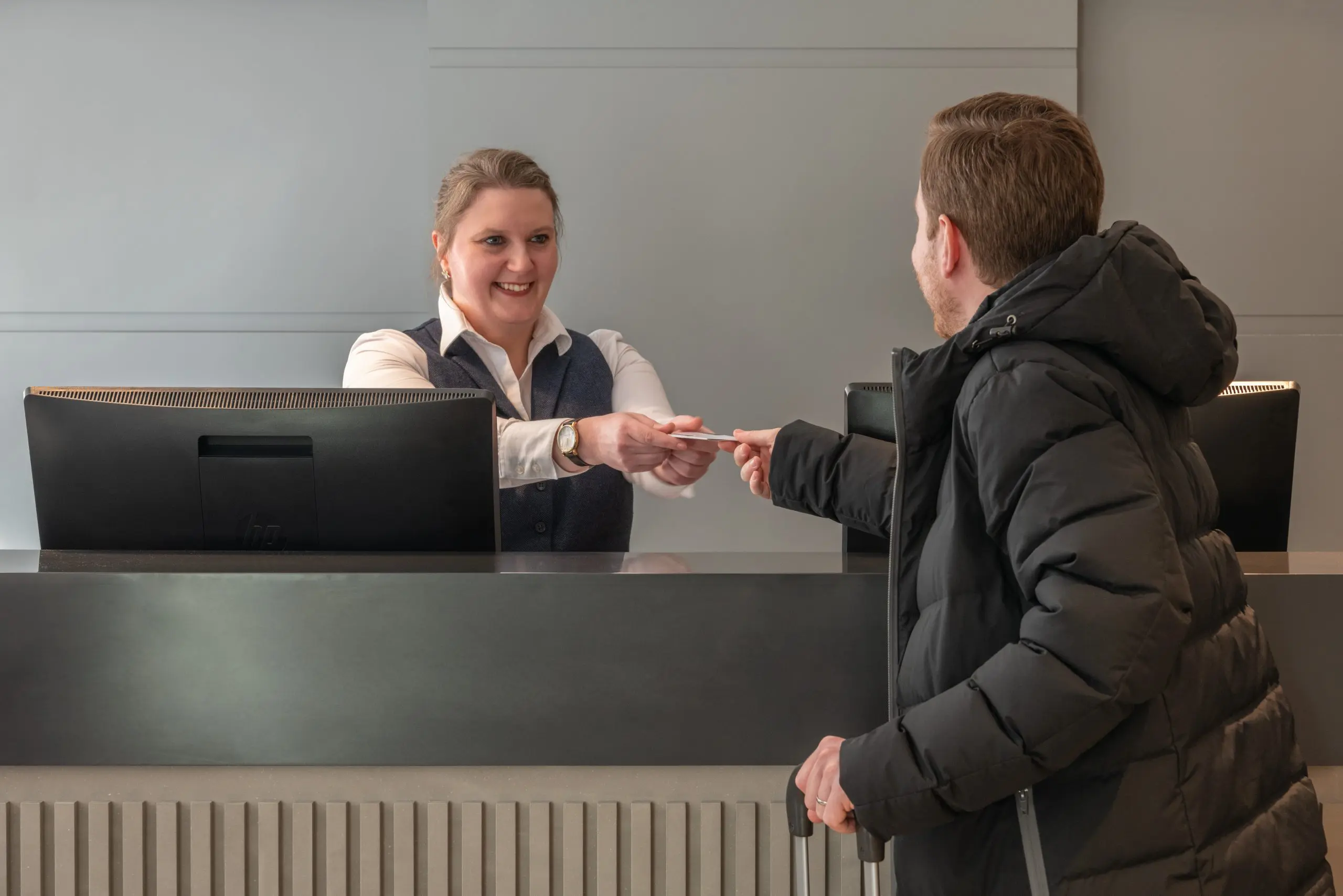 A customer receiving a key card at The Resident reception.