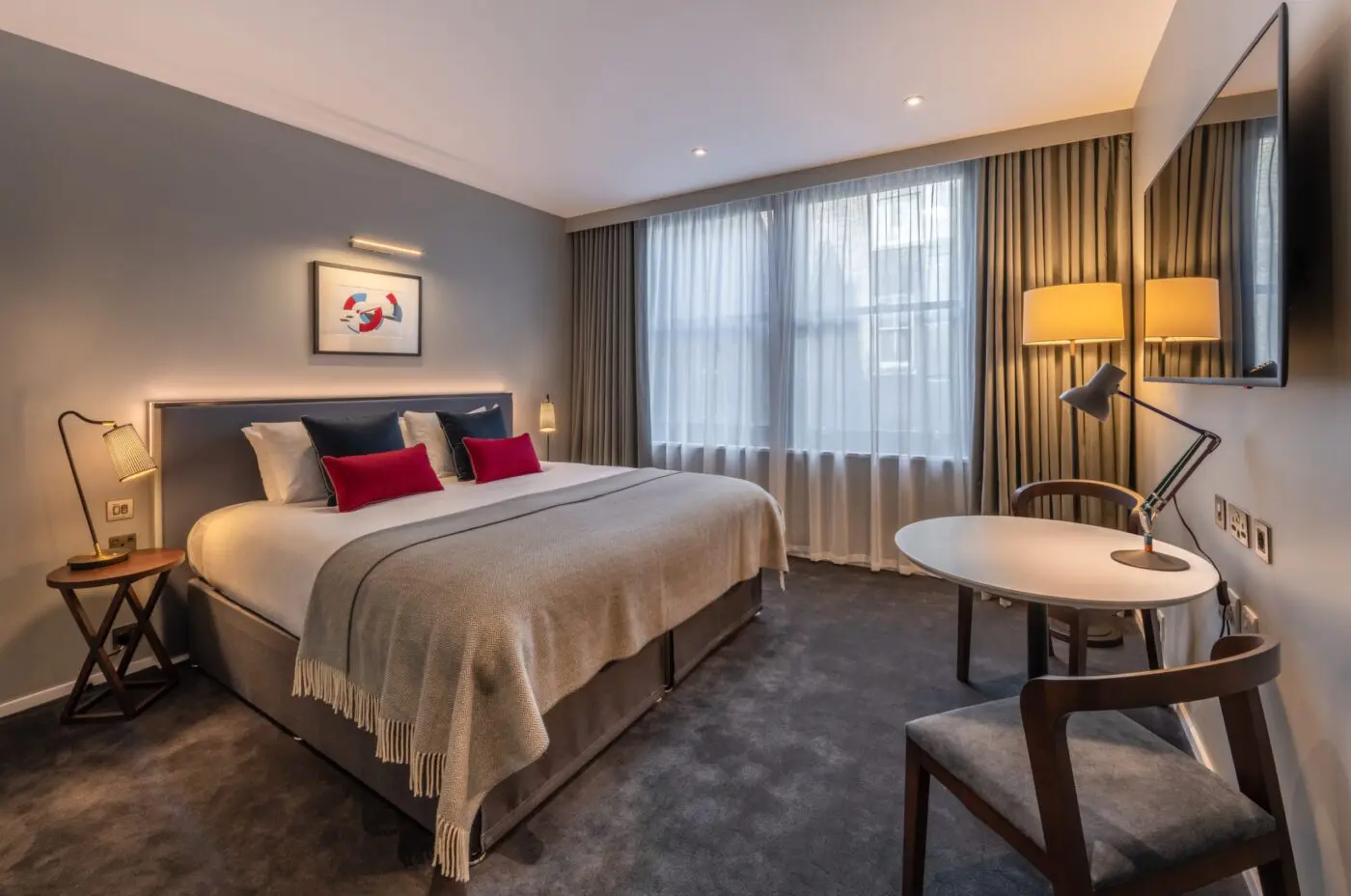 A superior room with a double bed, dining table and television, located in Covent Garden.