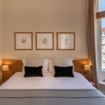 A deluxe room, with a double bed and bedside tables, located in Kensington.