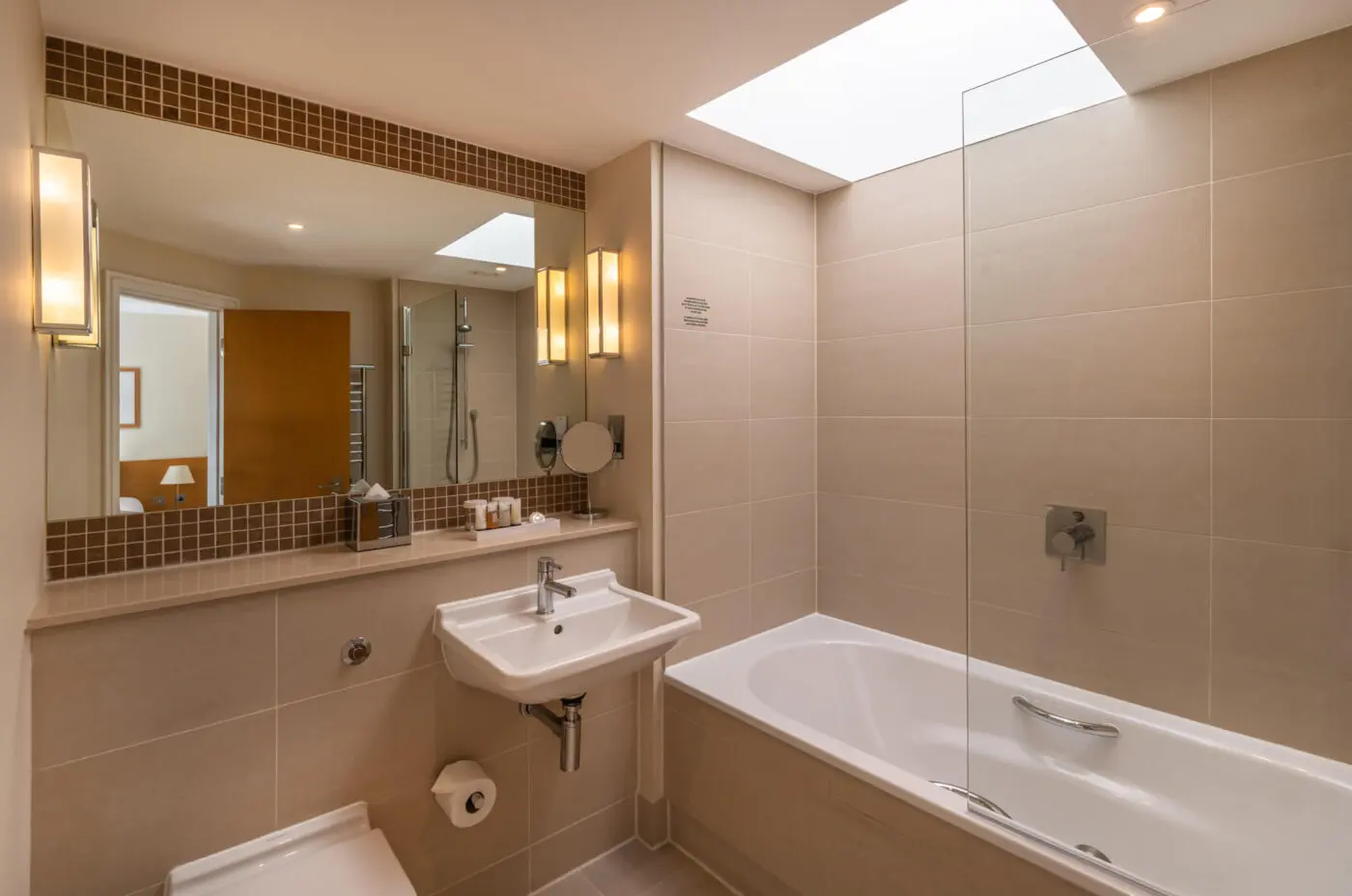 A superior bathroom with a large built in mirror and bathtub, located in Kensington.