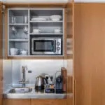 A miniature kitchen, with a built in fridge and microwave.