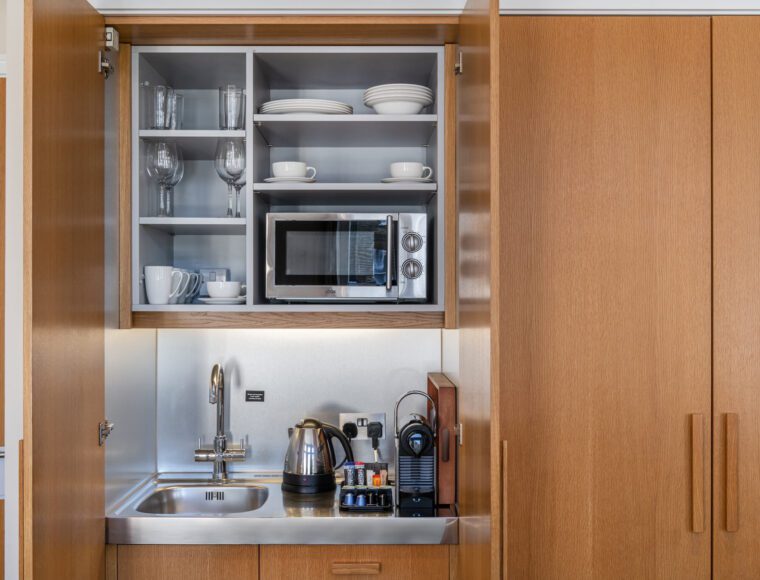 A miniature kitchen, with a built in fridge and microwave.