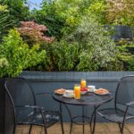 A patio with two dining chairs and breakfast.