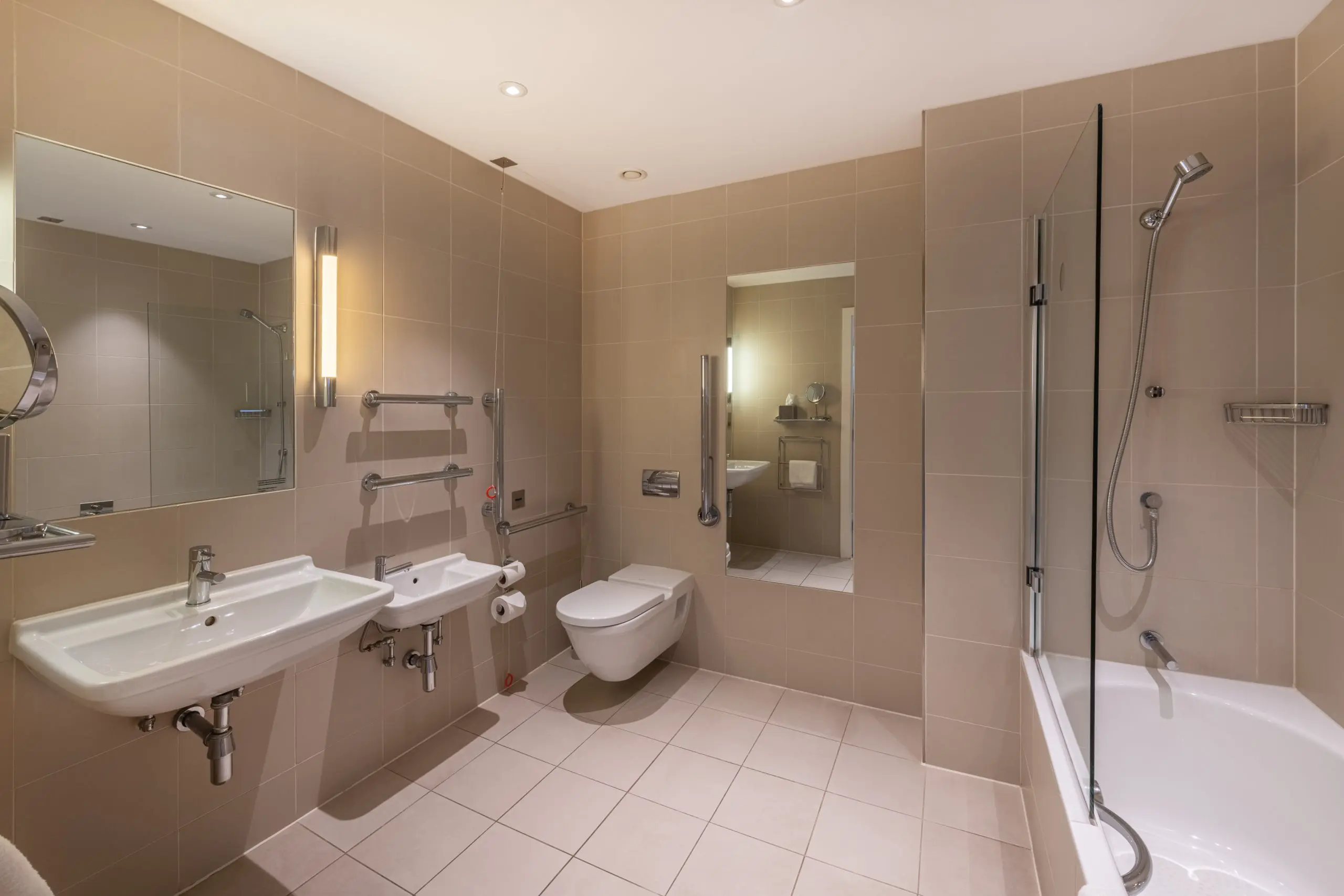 A large bathroom with a shower, bathtub and two sinks, located in Liverpool.