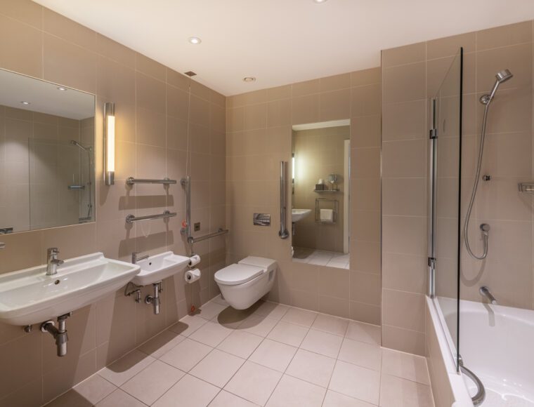 A large bathroom with a shower, bathtub and two sinks, located in Liverpool.