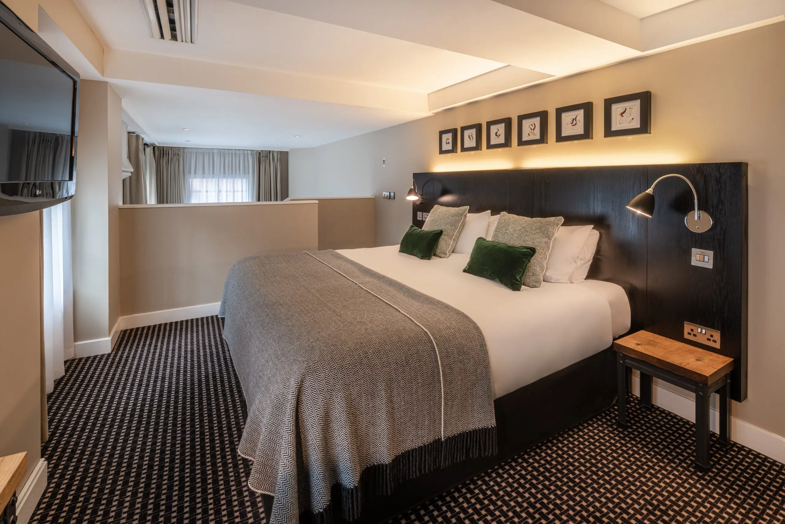 A junior sized suite, with a double bed, bedside tables and television.