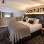 A junior sized suite, with a double bed, bedside tables and television.