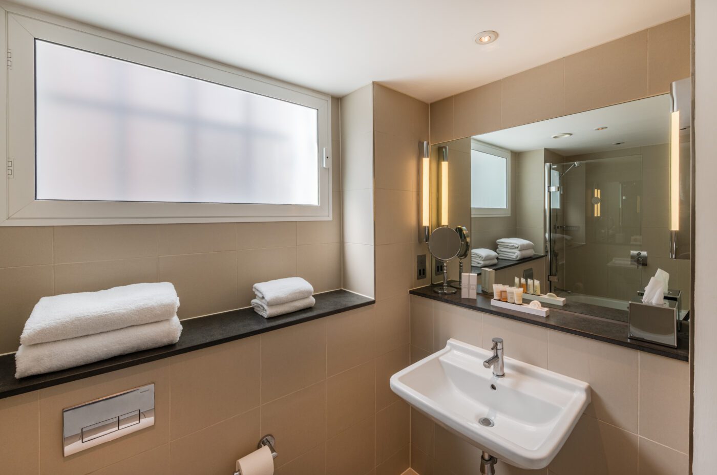 A junior suite bathroom, with shelves and amenities.