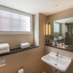 A junior suite bathroom, with shelves and amenities.