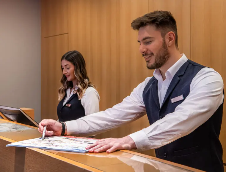 Two hotel professionals working at reception.