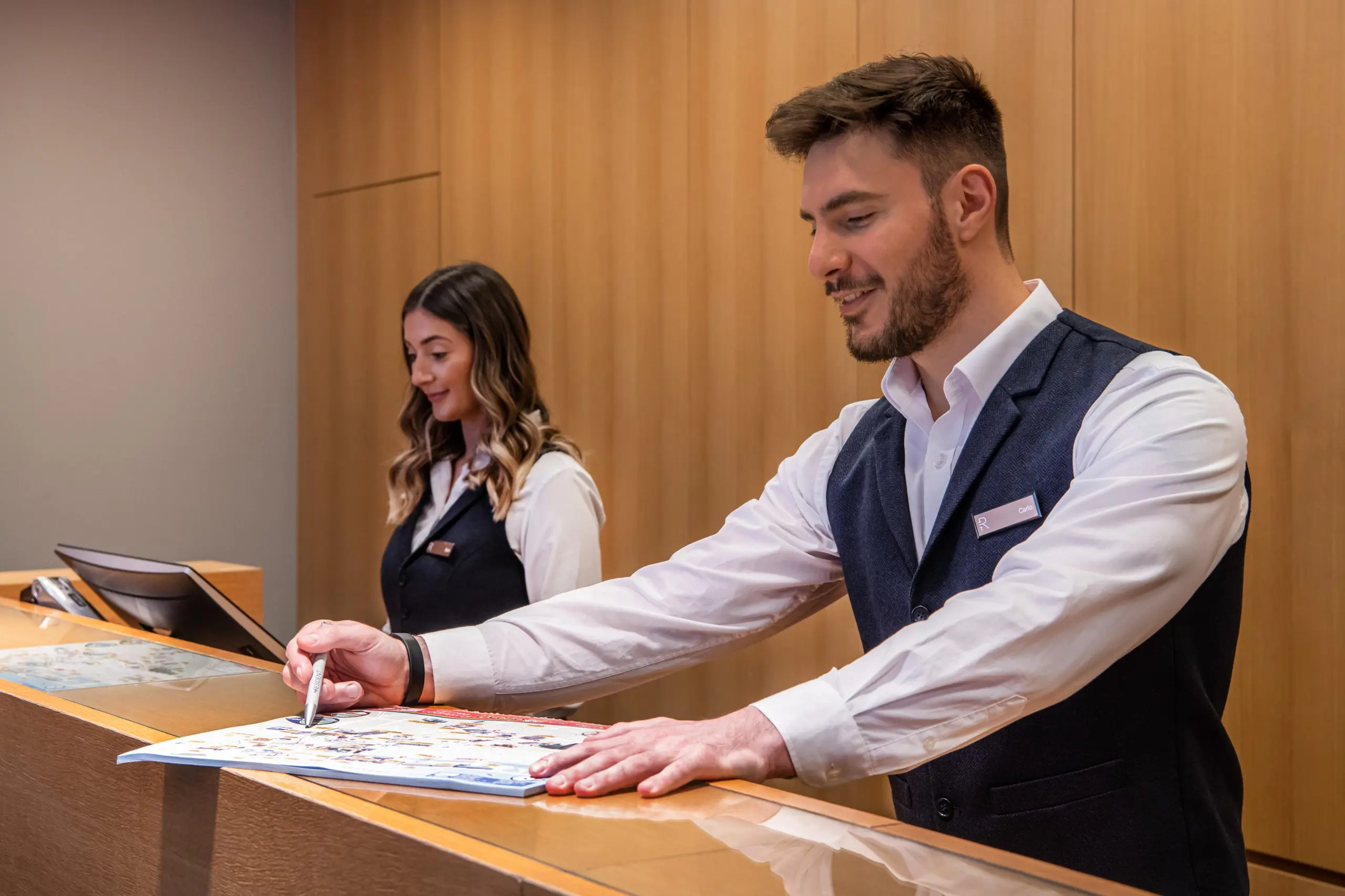 Two hotel professionals working at reception.