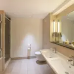 A large bathroom with a shower, bathtub and two sinks, located in Liverpool.