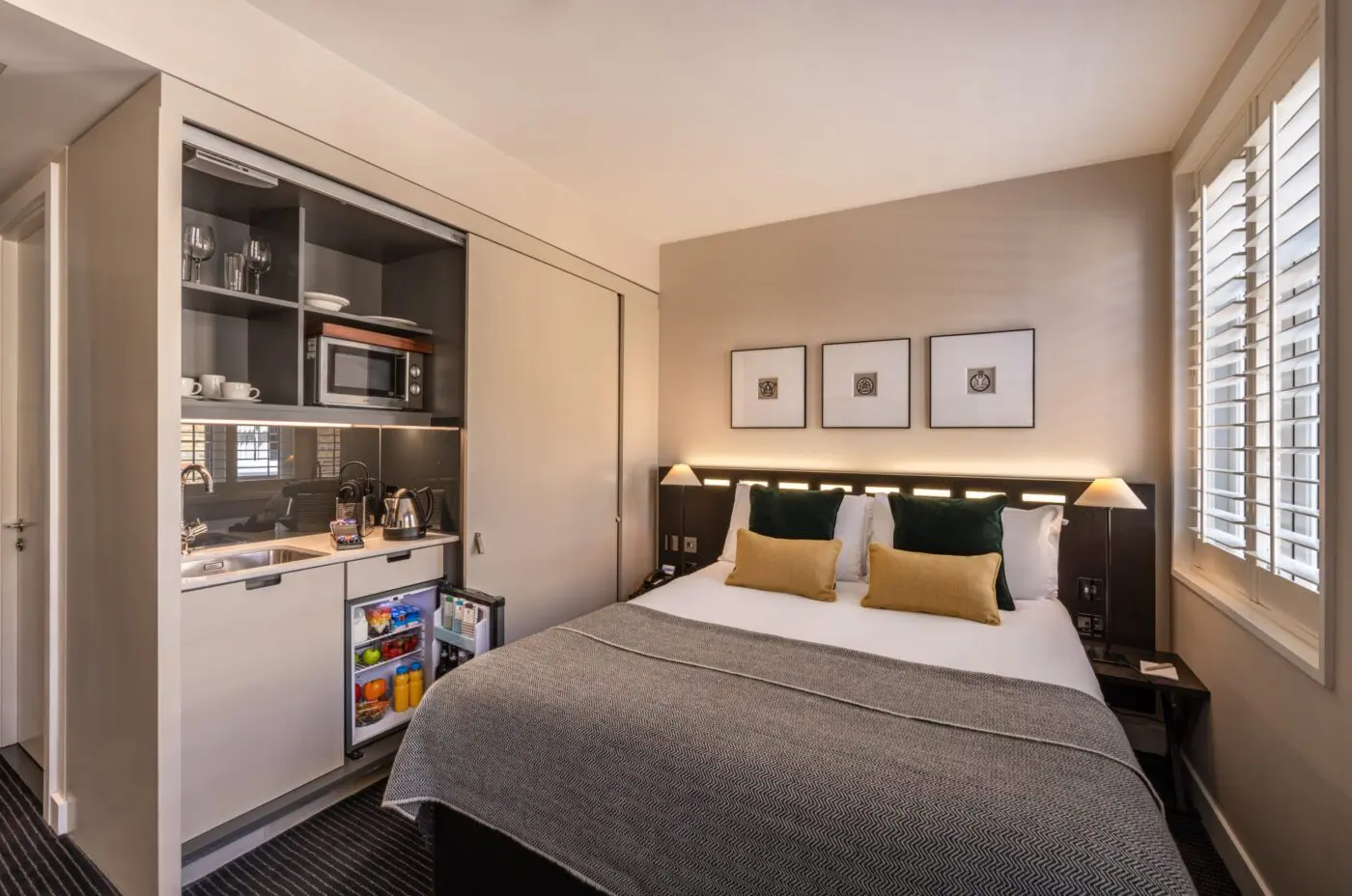 A double room, with bedside tables, double bed and built in miniature kitchen, located in Soho.