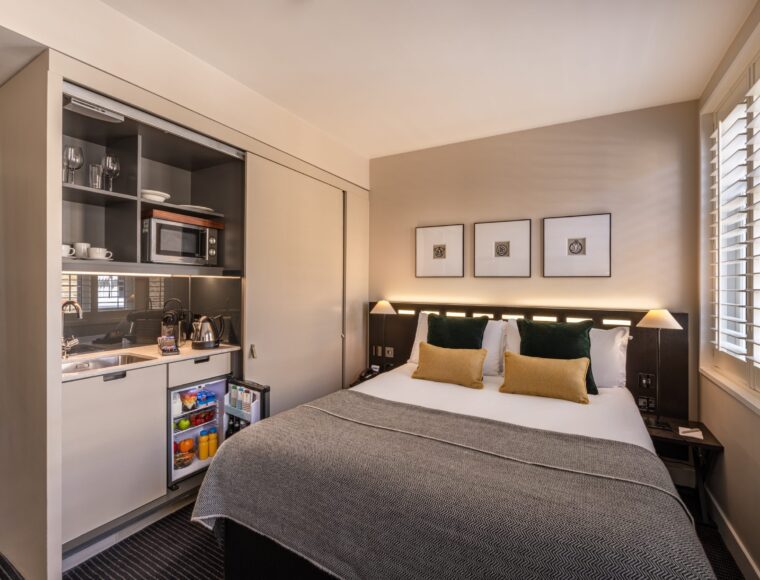 A double room, with bedside tables, double bed and built in miniature kitchen, located in Soho.