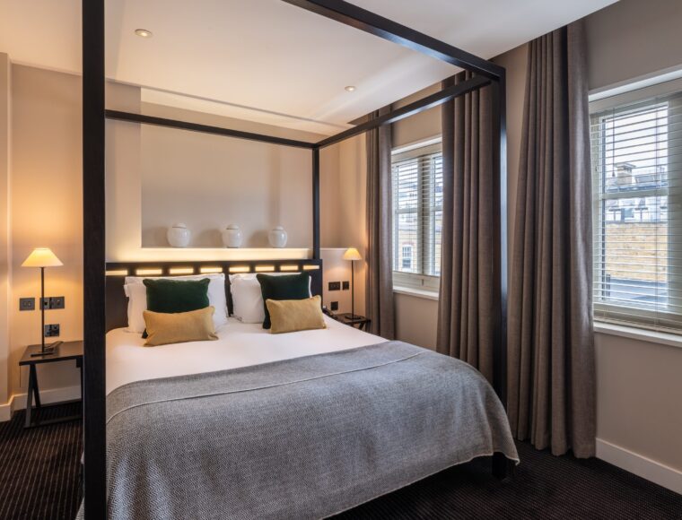 A large suite with a double bed and bedside table, located in Soho.