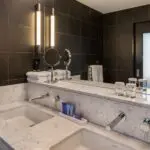 Bathroom counter with two sinks and kitchen amenities.