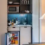 A built in miniature kitchen area with a fridge and microwave, located in Soho.