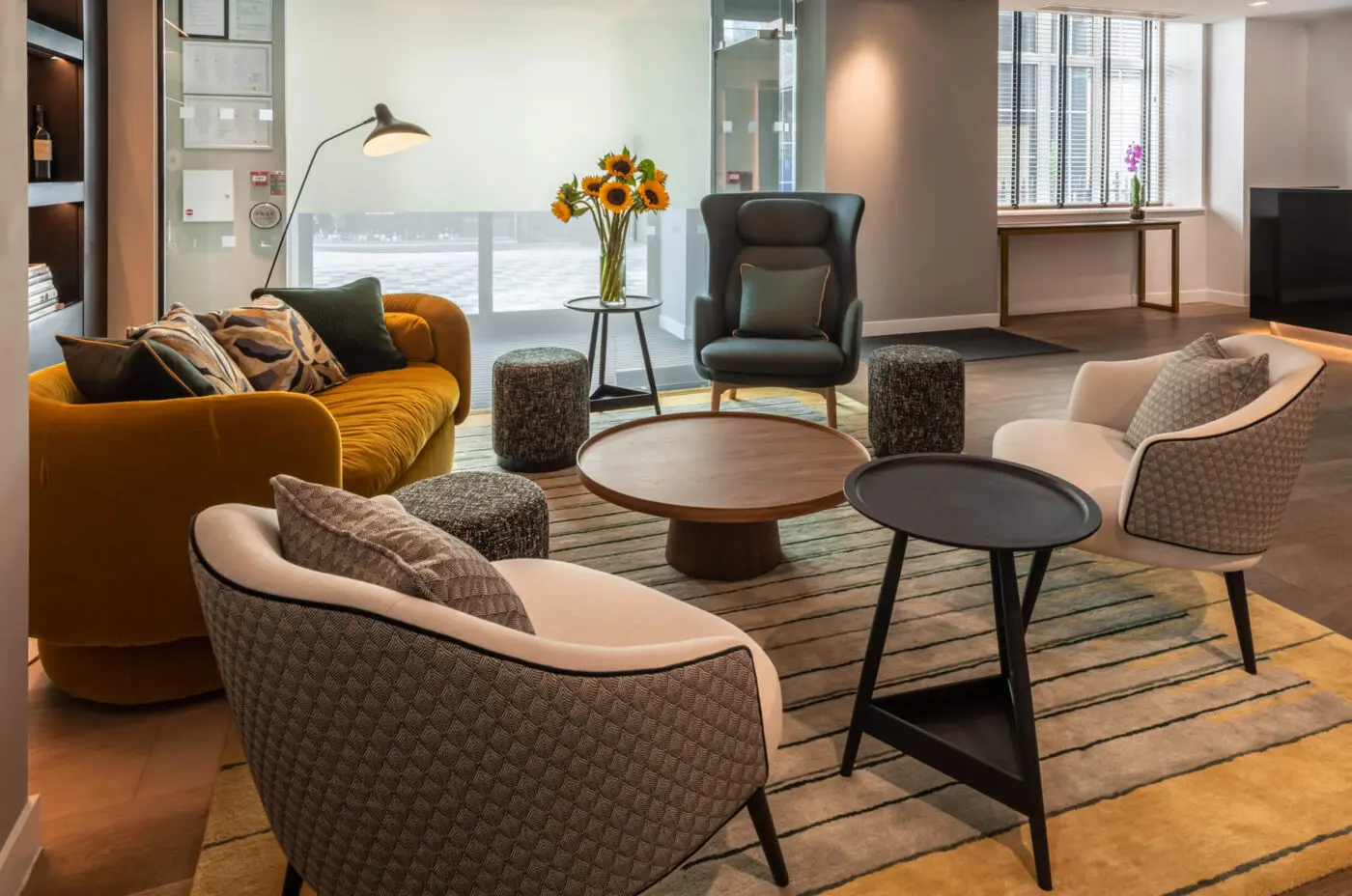 Hotel lounge with multiple arm chairs, a two coffee tables.