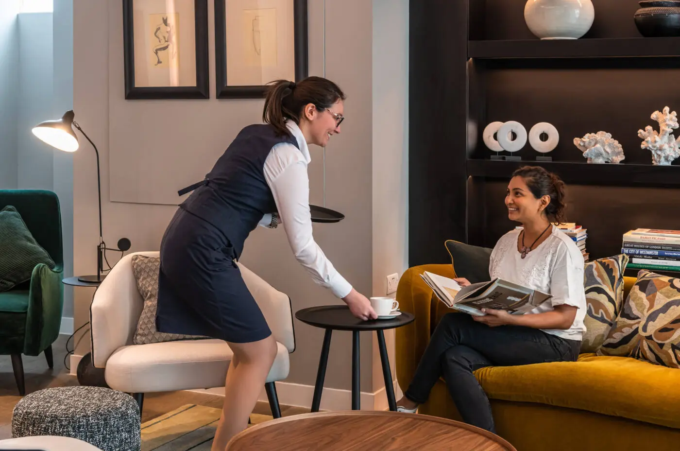 The Resident Victoria, a Resident team member offering coffee to a guest.