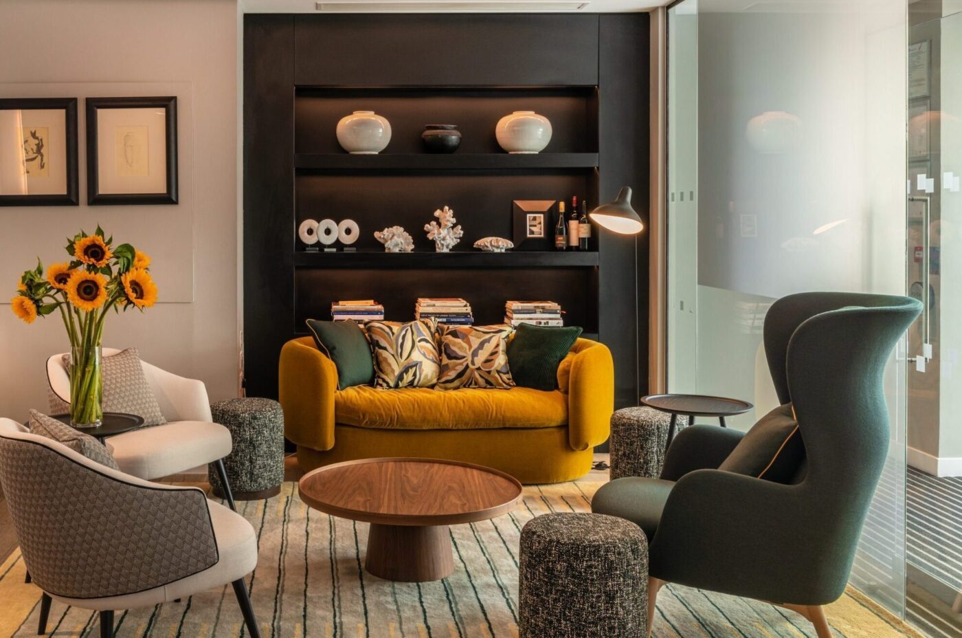 Lounge area with seating, coffee table with built in shelves holding ornaments and magazines.