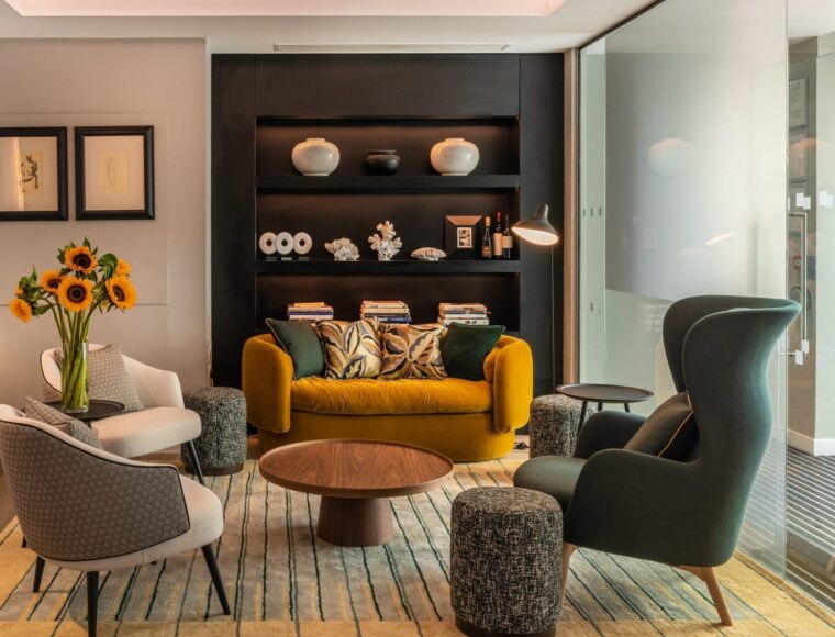 Lounge area with seating, coffee table with built in shelves holding ornaments and magazines.