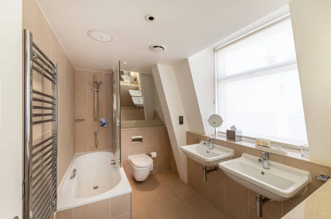 A large bathroom with a built in shower and bathtub and two sinks, located in Victoria.