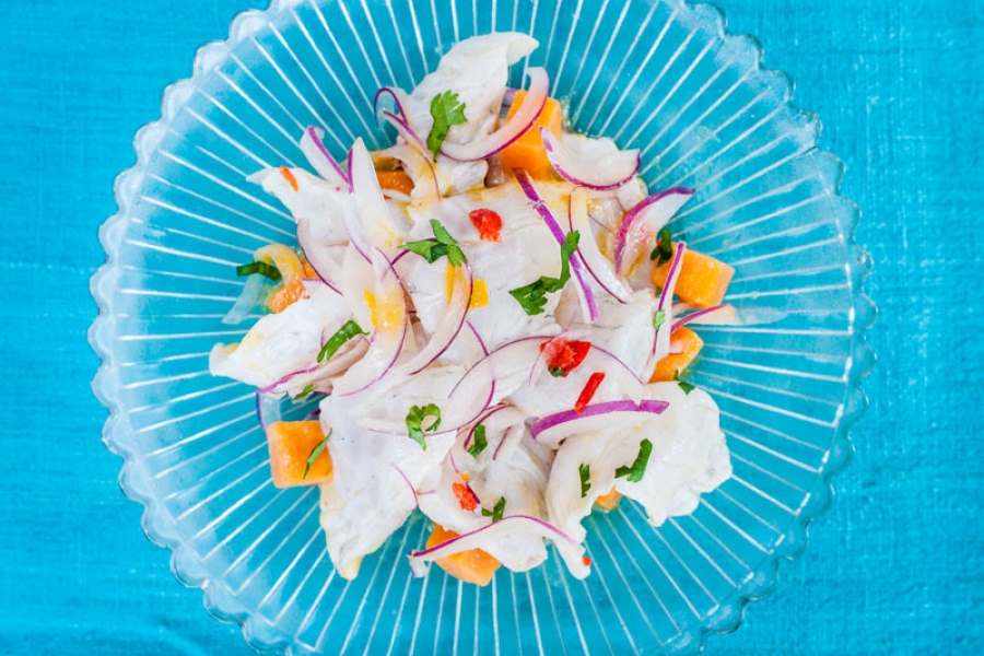 A clear plate, filled with Ceviche.