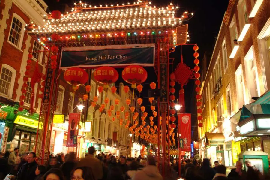 Nightlife in Chinatown, with lights, lanterns and crowds of people.