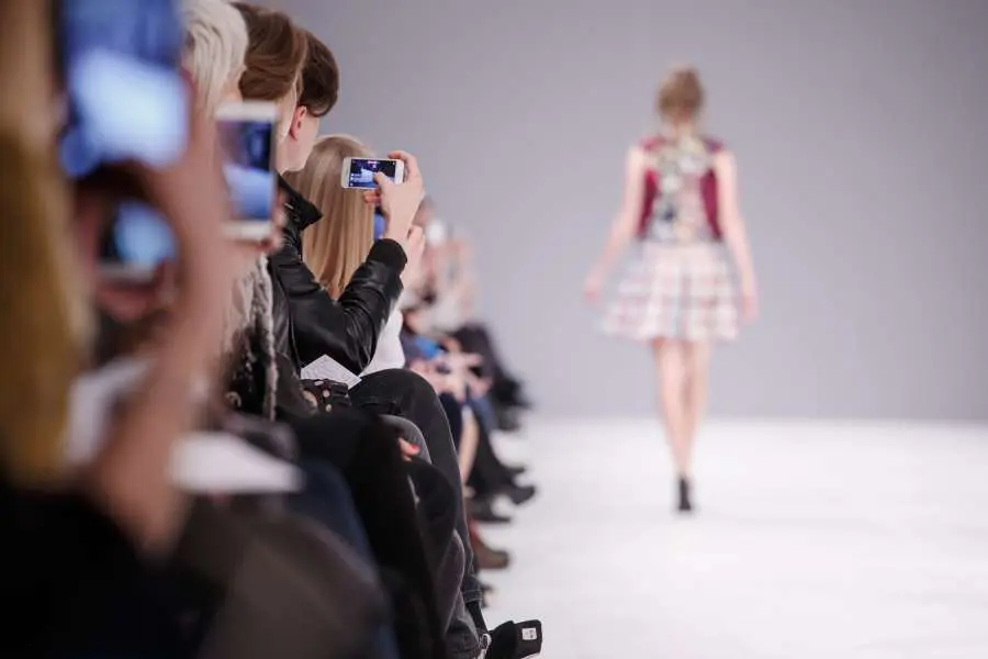 Individuals taking front row photos of a model in London Fashion Week