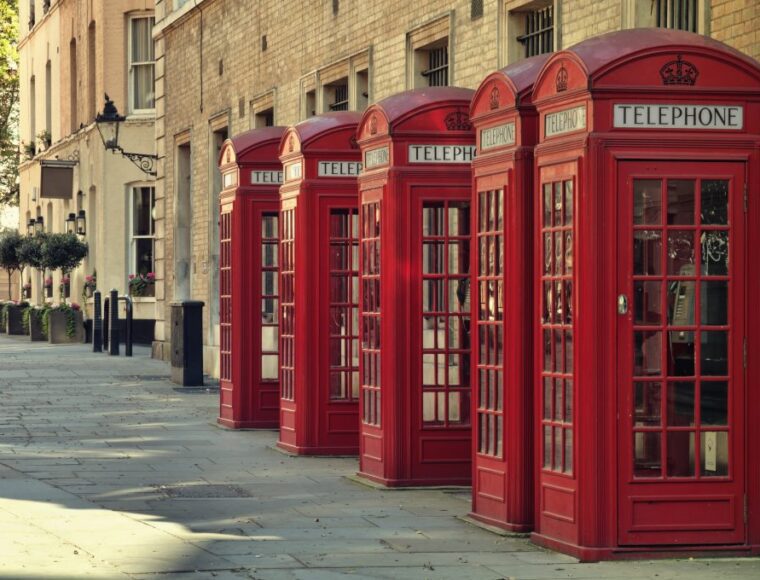 A row of red telephone boxes in London.