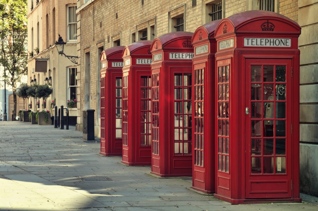 A row of red telephone boxes in London.