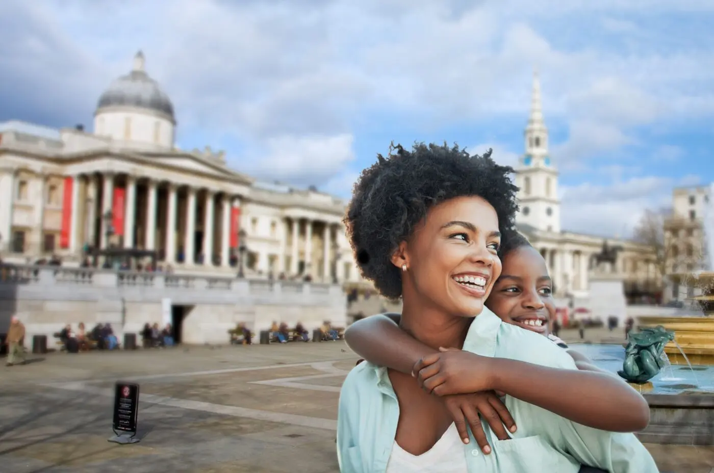 A mother and child smiling, whilst exploring Trafalgar Square.