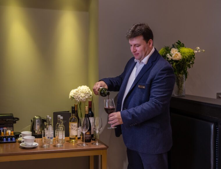 A team member pours wine for guests.