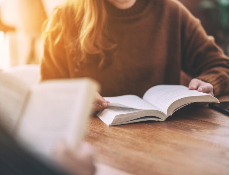 Group of people sitting and enjoyed reading the book behind One Day Netflix together on wooden table