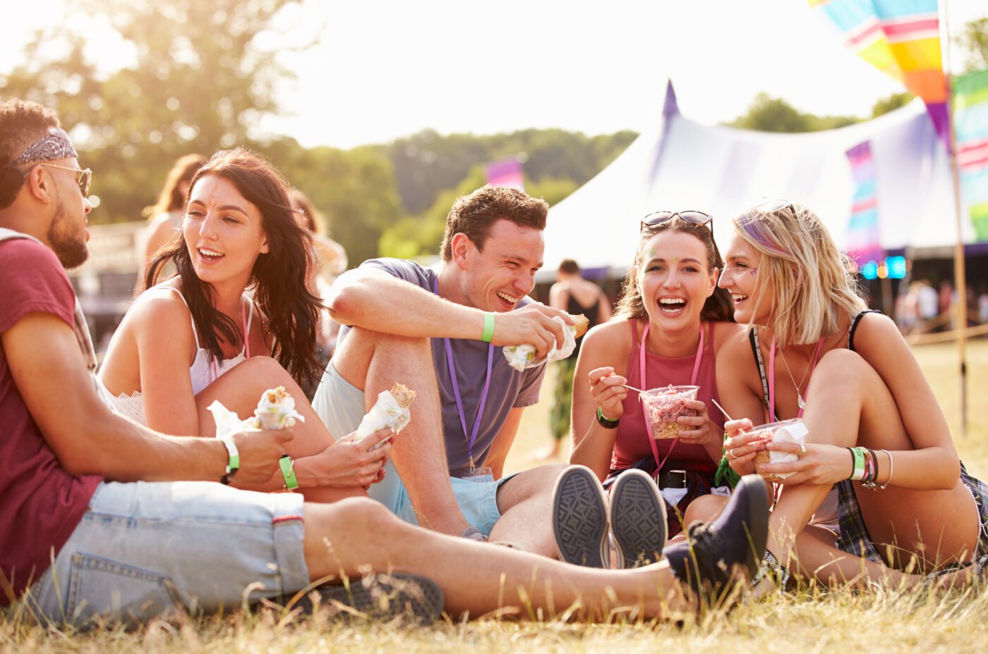 Friends sitting on the grass eating at Taste of London Festival, Regent's Park.