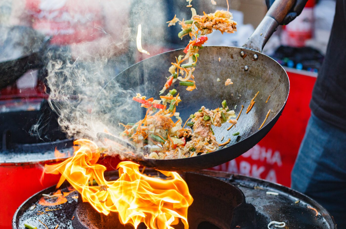 chef cooks Chinese noodle wok at Taste of London 2024.