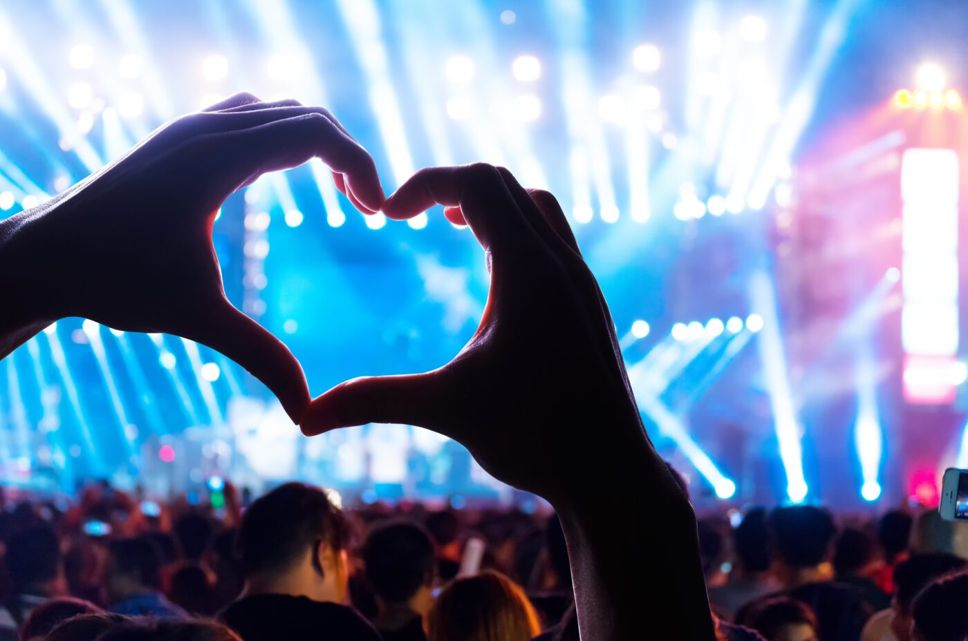 Silhouette of a heart shaped hands and crowd of Audience at the Taylor Swift Eras Tour Concert during the Fearless Set.
