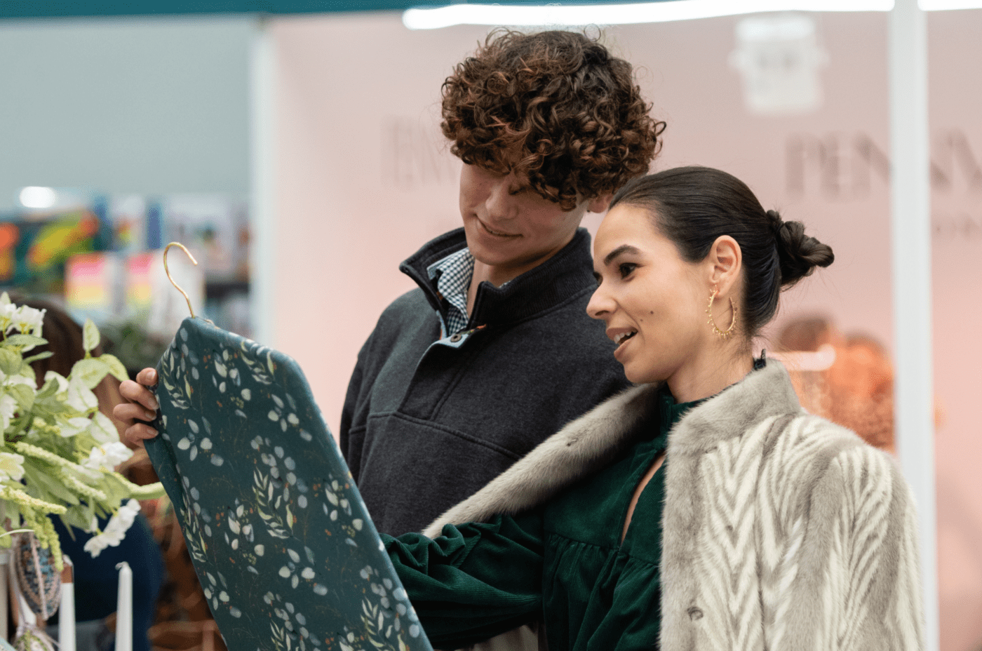 A couple shops at The Spirit of Christmas Fair at London Olympia, in Kensington