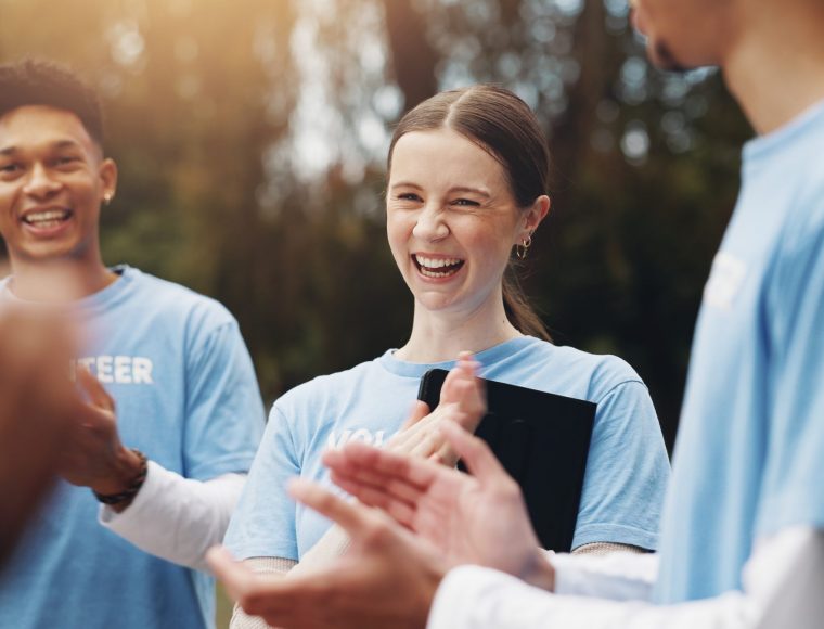 Three people wearing matching light blue shirts with 