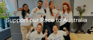 Six smiling people pose together indoors, wearing matching white "Virtual Sapi" shirts and making enthusiastic gestures. Large text over the image reads, “Support our Race to Australia.”.