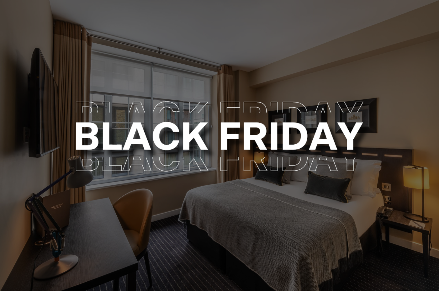 A modern hotel room with a neatly made bed, desk, chair, and large window. The words 